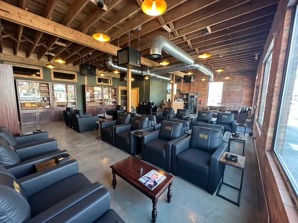 Finished cigar-lounge interior with the completed Unlimited spiral duct and minisplit heads, leather chairs, and warm pendant lighting