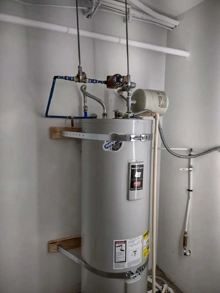 Bradford White electric water heater installed with an expansion tank and shutoff valves overhead