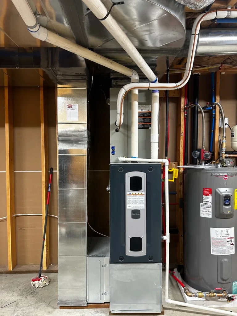 American Standard high-efficiency furnace beside a Rheem Performance Platinum heat-pump water heater in a tidy utility-room install